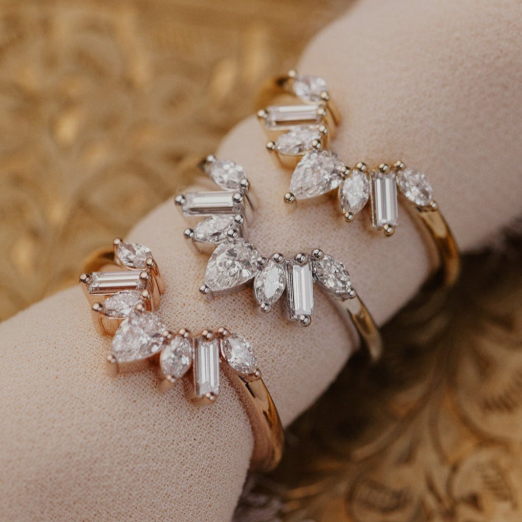 14k gold wedding band featuring pear, marquise, and baguette diamonds set in prongs in a starburst design.