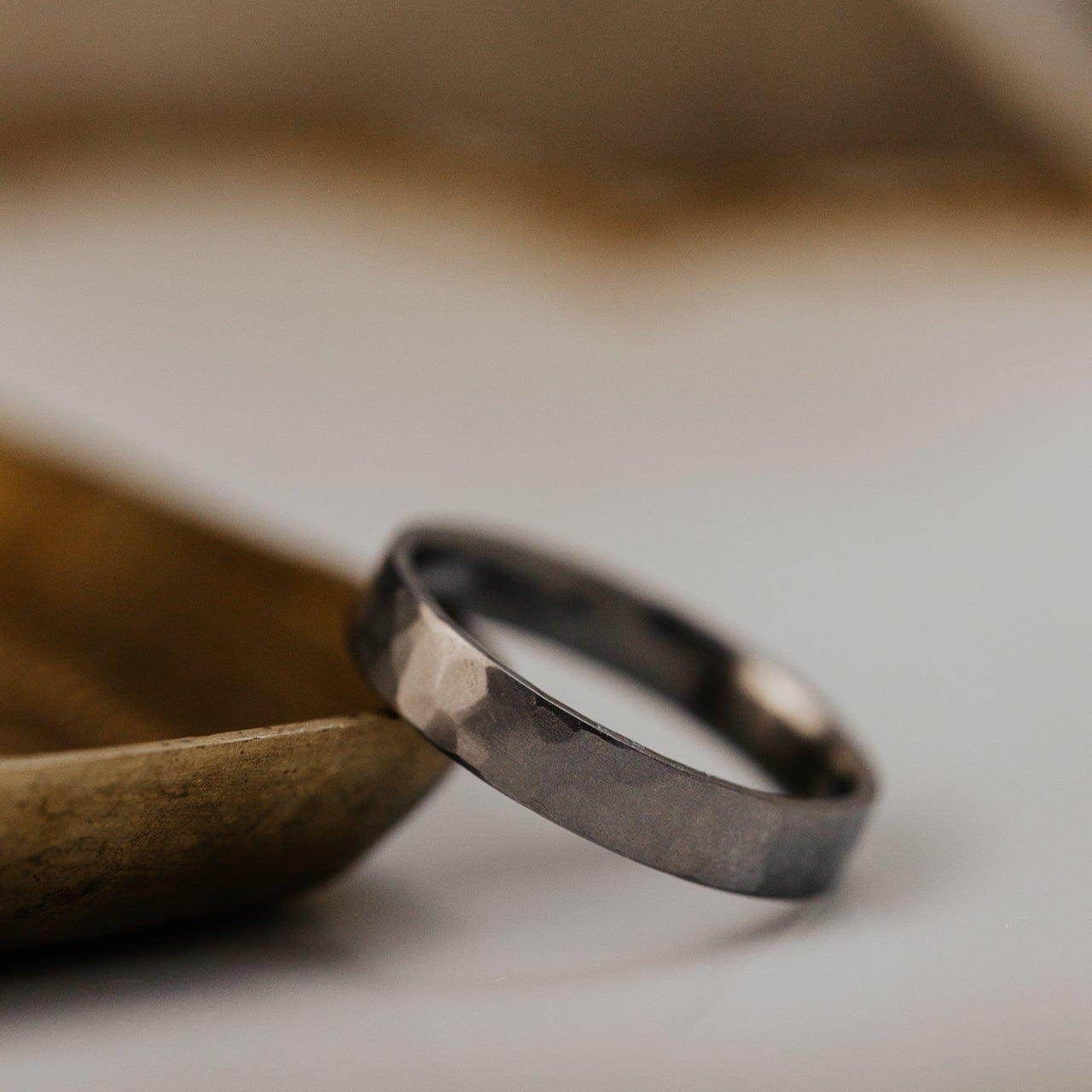 Titanium band on a wooden surface with a blurred background