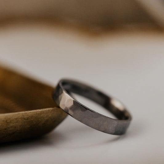 Titanium band on a wooden surface with a blurred background