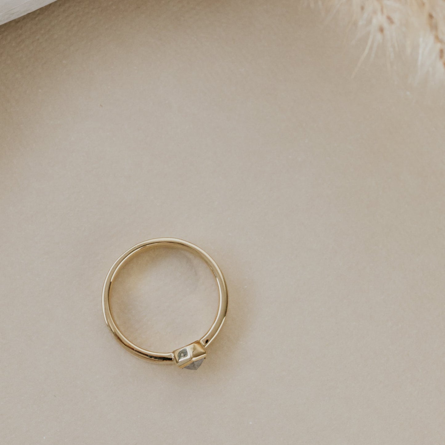 Gold ring on a beige surface.