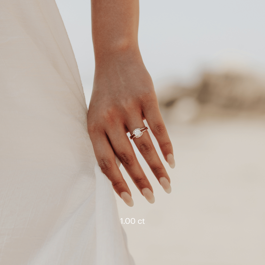 The Hampton Round Ring in 14k yellow gold featuring a lab-grown round diamond center stone with starburst diamond halo on a split shank band, worn on the ring finger.