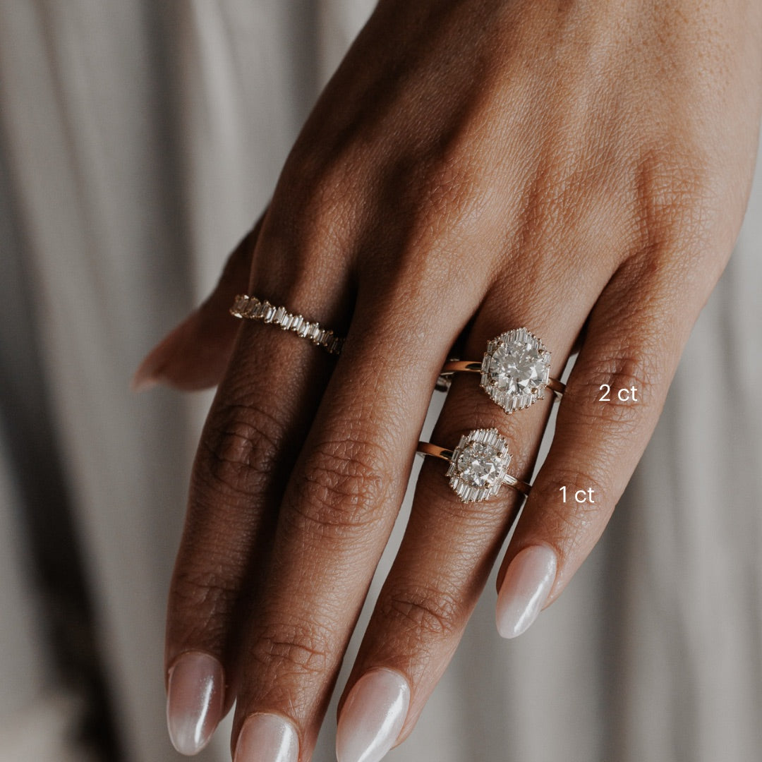 The North Star Ring in 14k yellow gold shown in two center stone size options worn on the hand: 2 ct and 1 ct, styled with a baguette diamond band on the pointer finger.