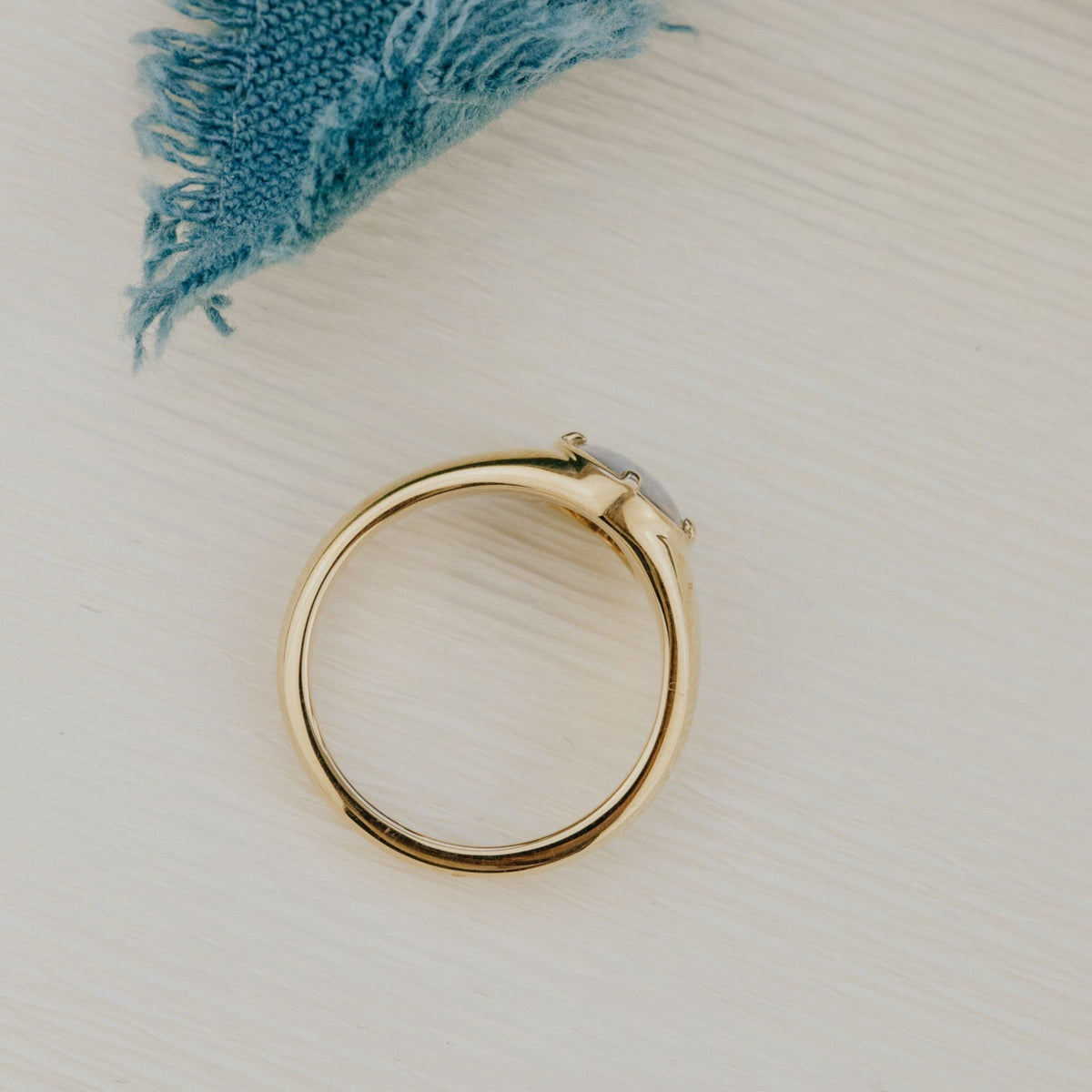 Triplet Opal Signet ring on a white surface.