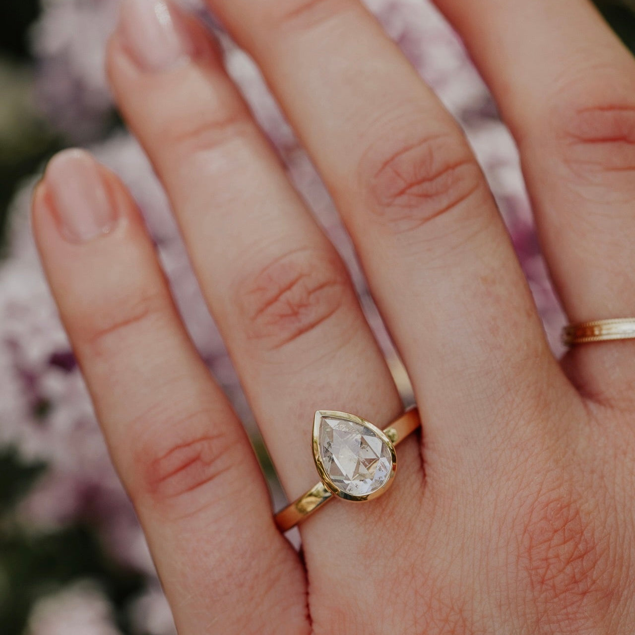 14k gold ring featuring a clear pear rustic rose cut diamond set in a bezel design.