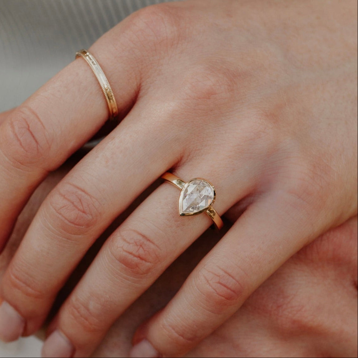 14k gold ring featuring a clear pear rustic rose cut diamond set in a bezel design.