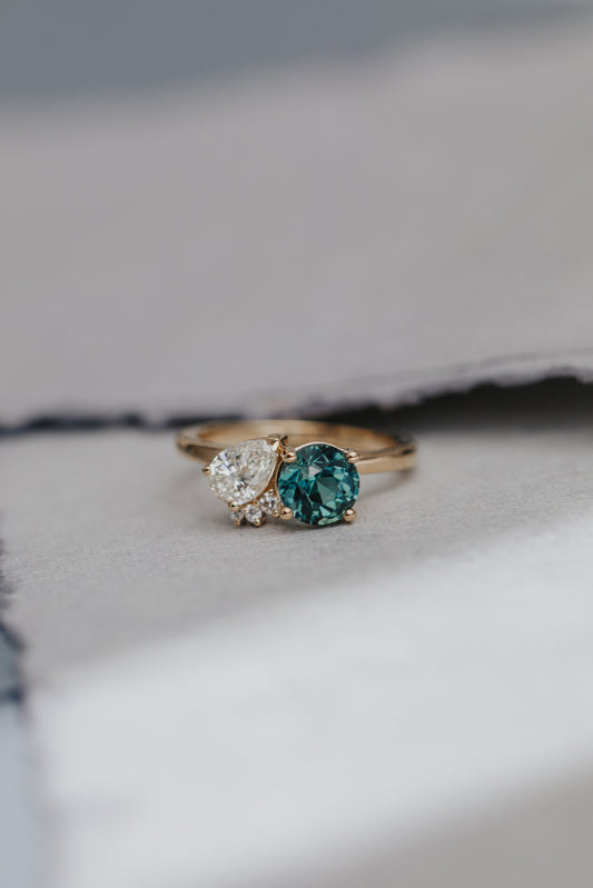 The Toi et Moi 1.70 ct Round Teal Sapphire and .50 ct Pear Diamond Ring