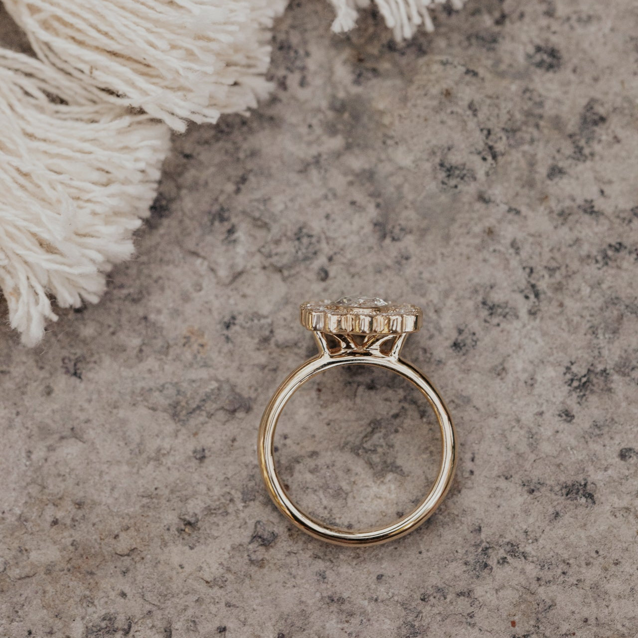 Gold diamond ring with a diamond on a textured stone surface