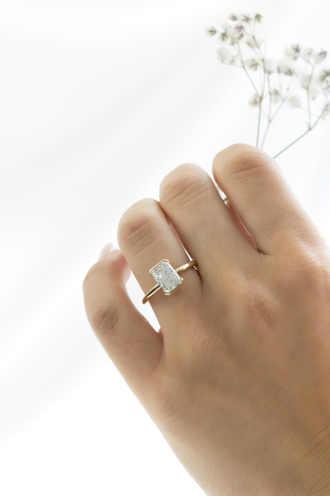 The Zadie Radiant Cut Half Bezel Solitaire Ring on a models hand