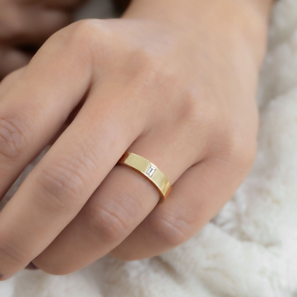 The Jaden Baguette Band in 14k yellow gold on a models hand