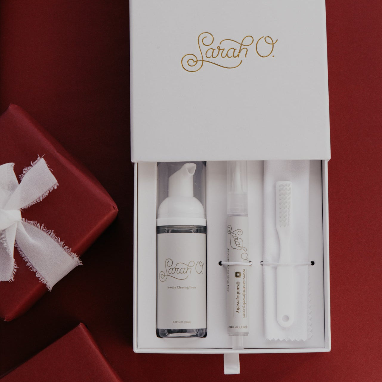 jewelry care product set with 'Sarah O.' branding on a red background