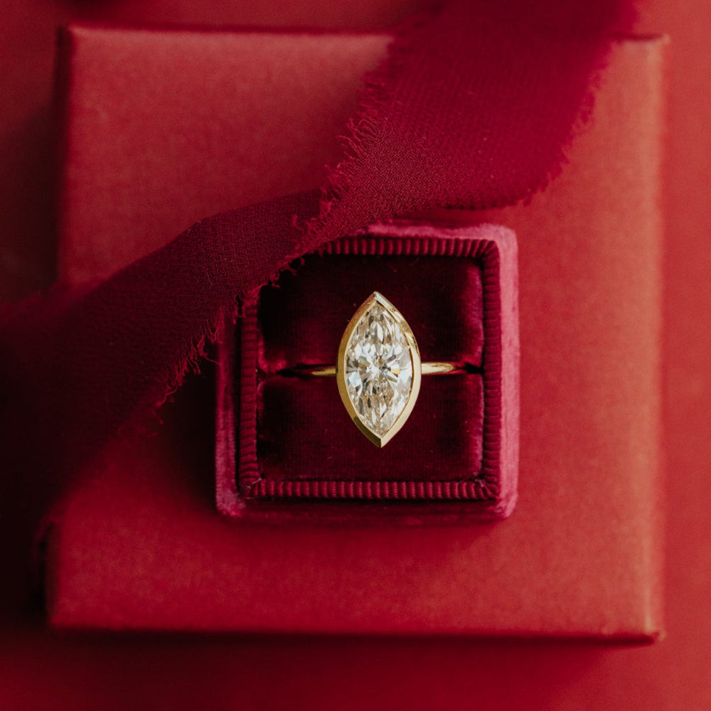 Marquise diamond ring in a red box with a red ribbon