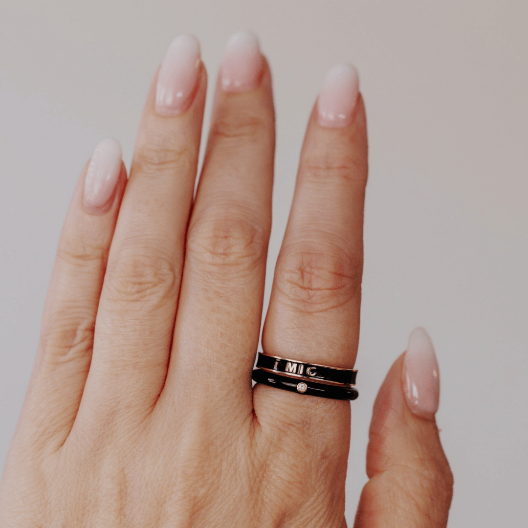 Black enamel rings stacked on a models hand.