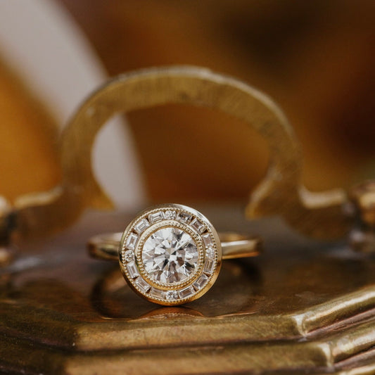 Round diamond with a halo on a decorative wooden surface