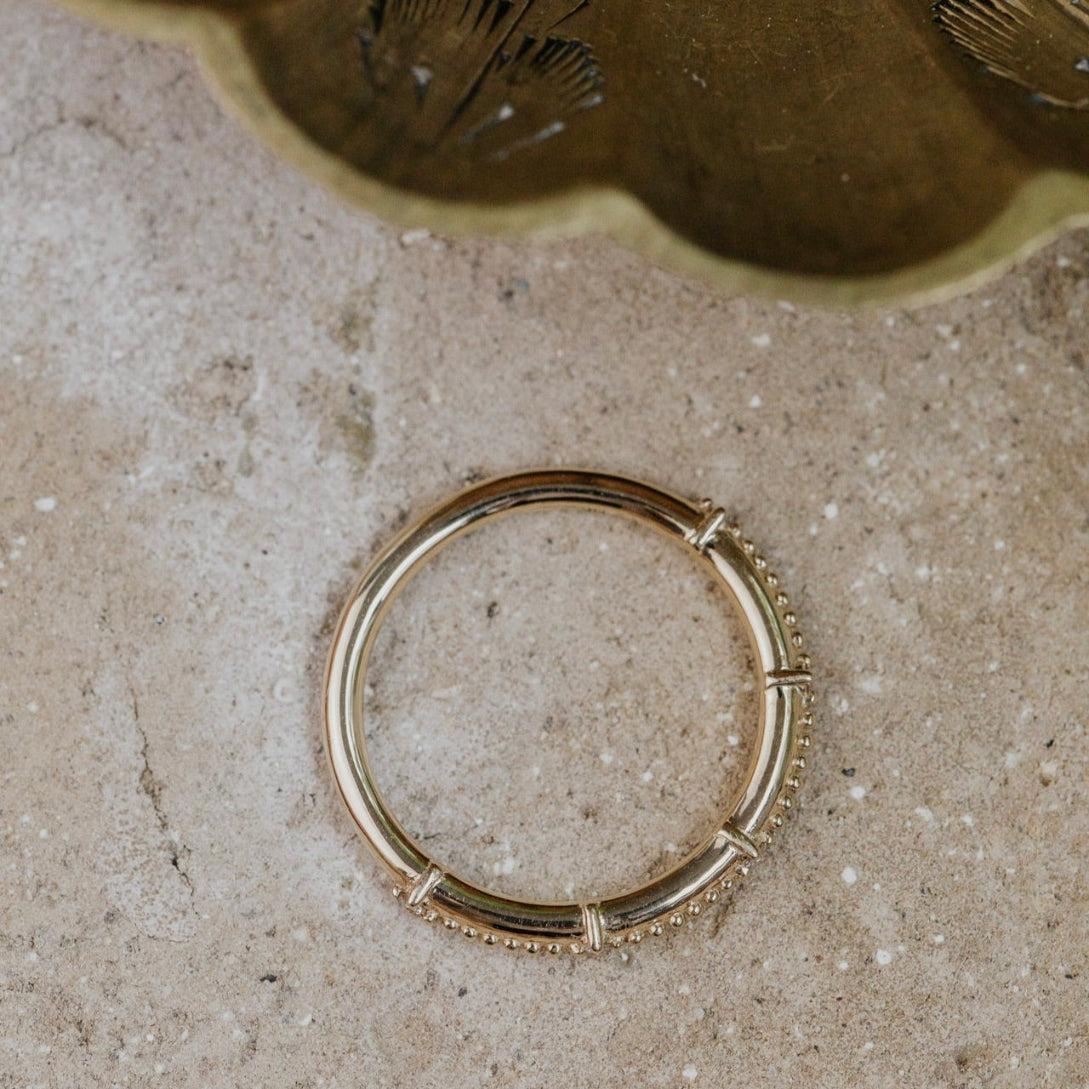 Gold band with textured design on a textured surface