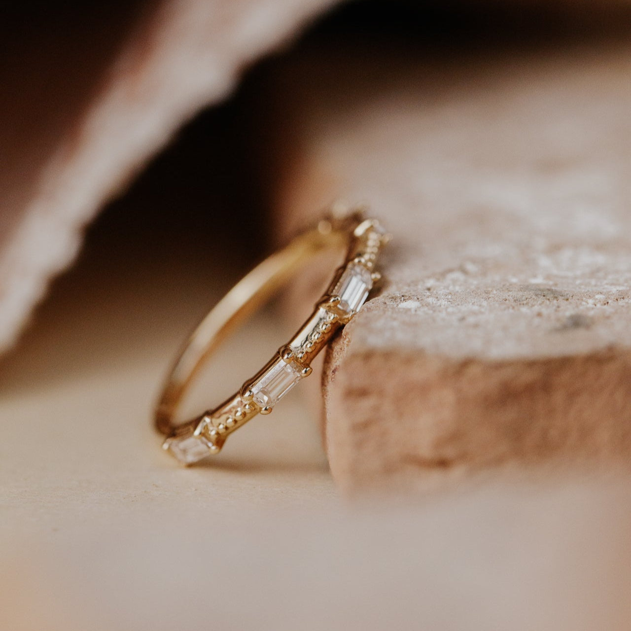 Gold band with baguette diamonds on a textured surface