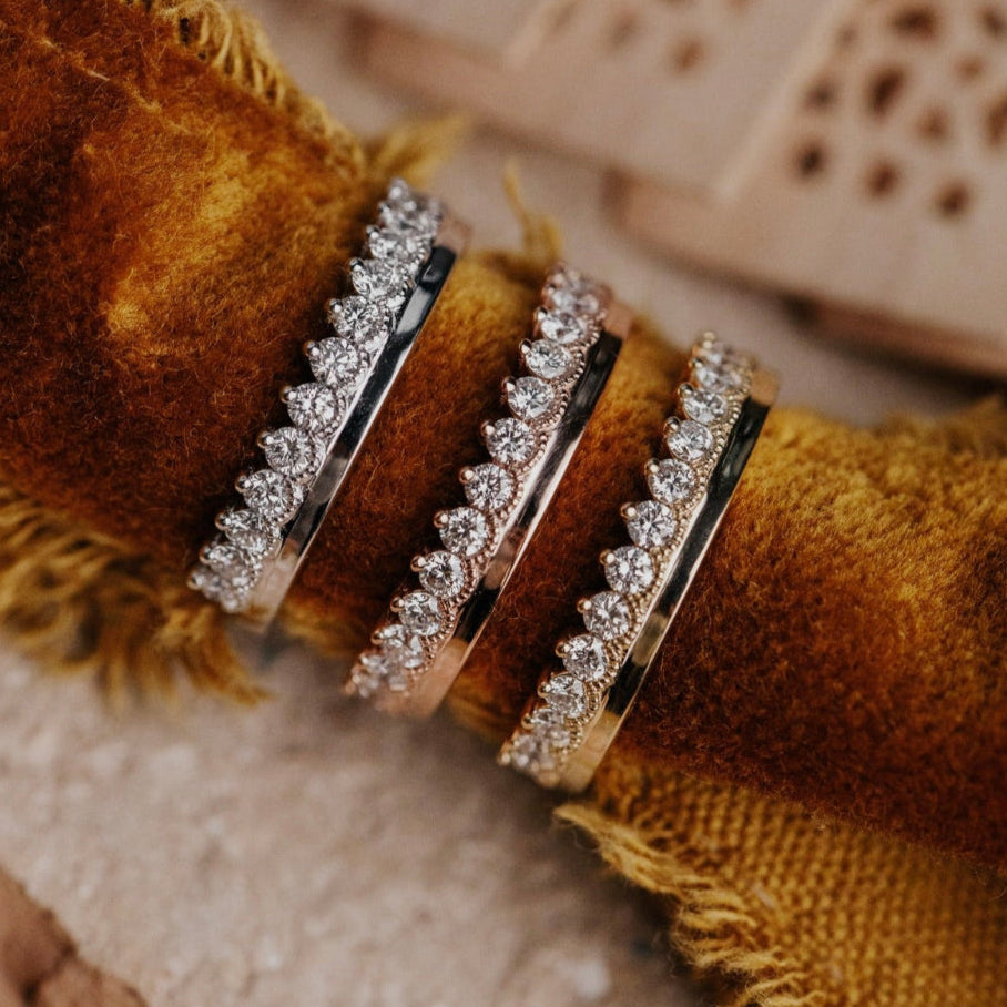 Stack of diamond rings on a textured brown fabric background