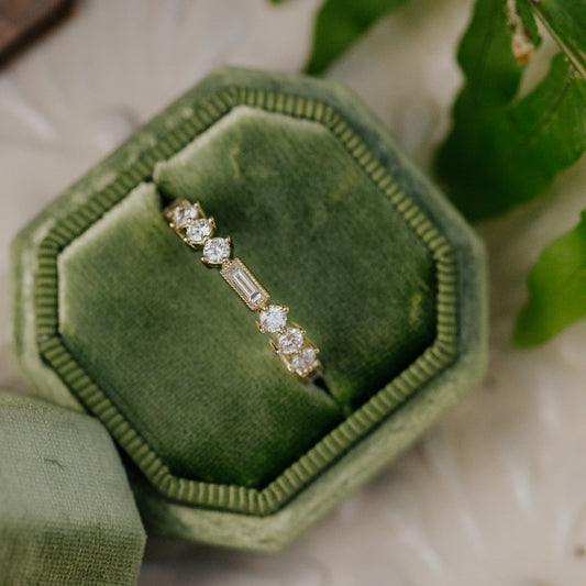 Diamond band in a green velvet box with fern leaves in the background