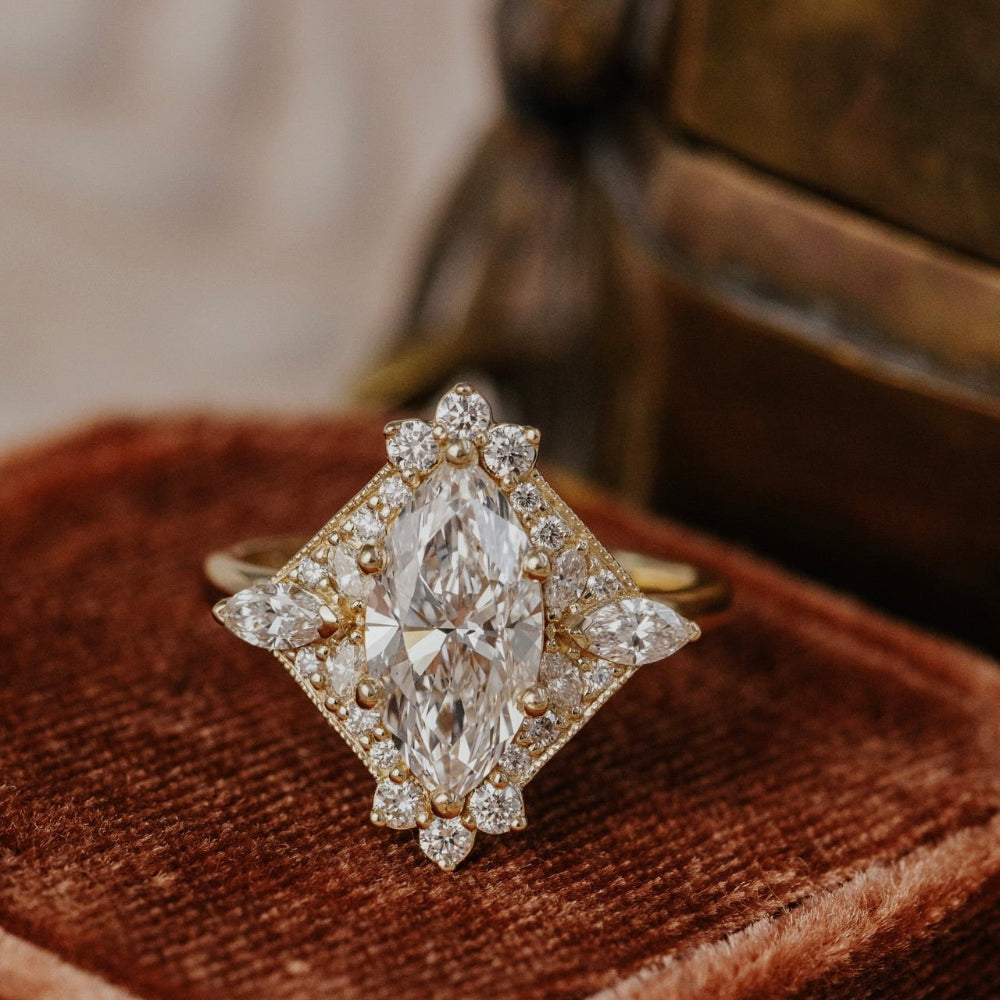 Marquise diamond ring on a brown velvet cushion with a blurred background