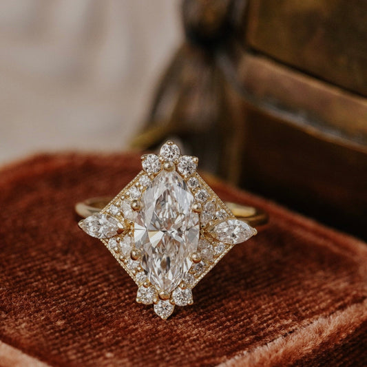 Marquise diamond ring on a brown velvet cushion with a blurred background