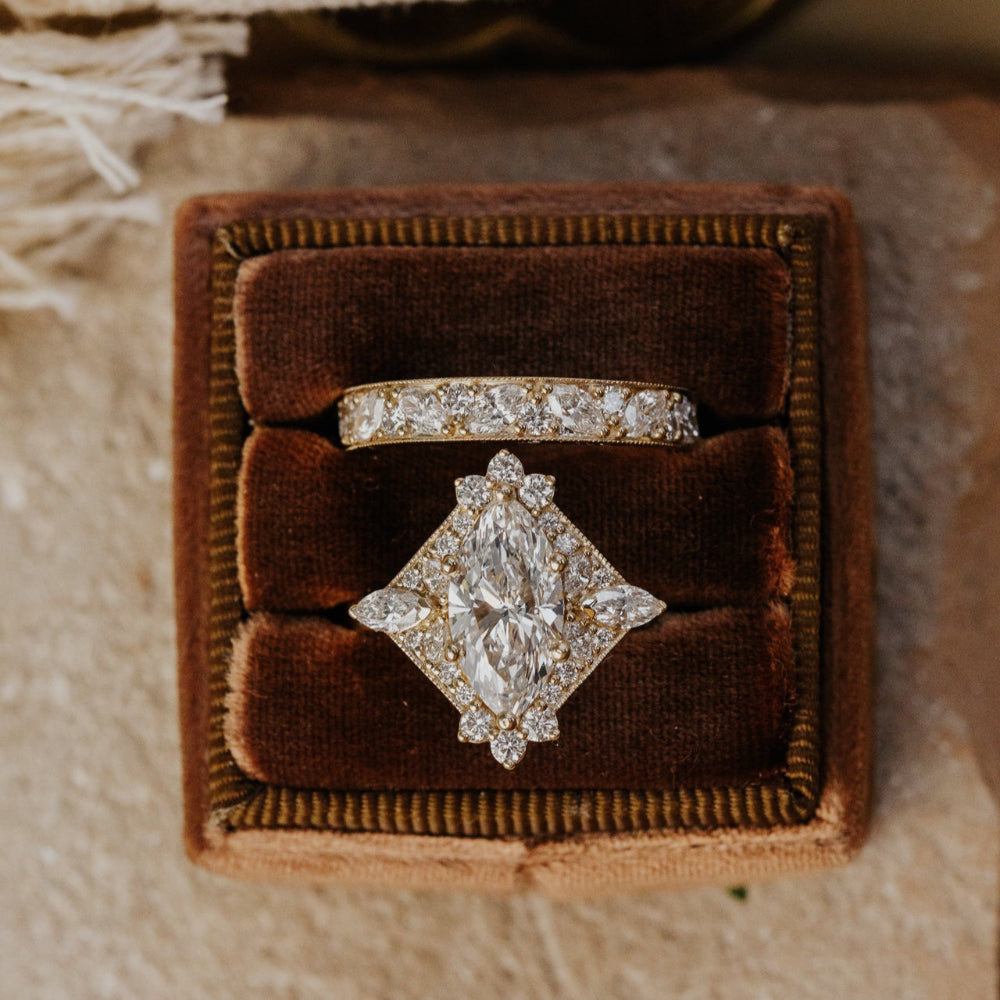 Diamond ring in a brown velvet box on a textured surface