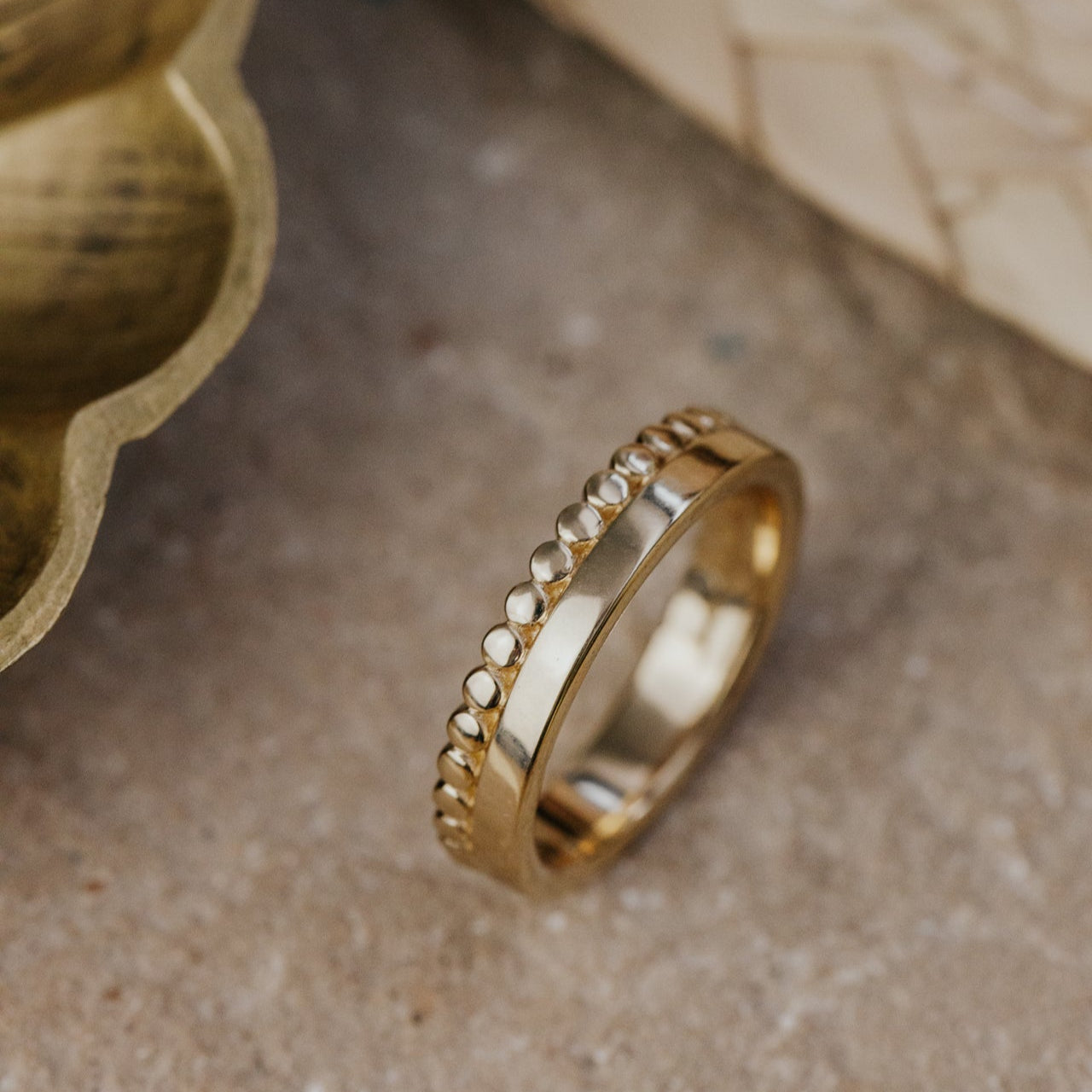 Gold beaded with a beaded textured on a textured surface