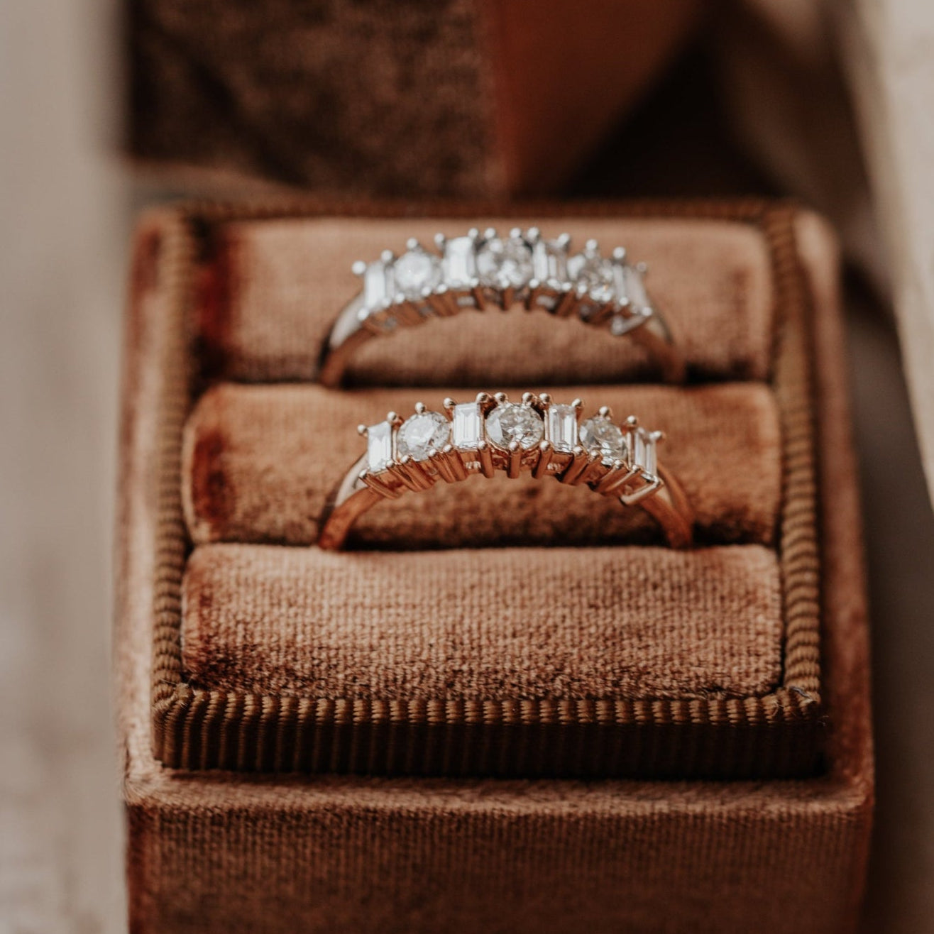 Two diamond wedding bands in a brown velvet box.