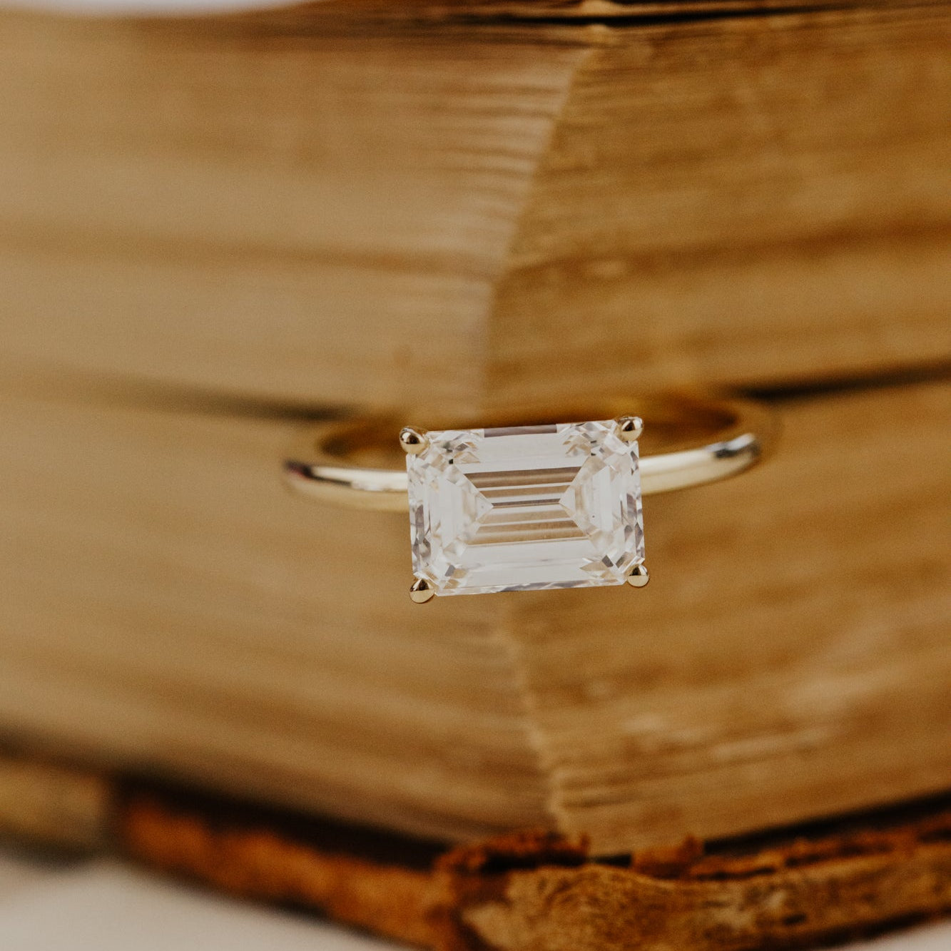 The Bennett 2.52 ct emerald cut lab grown diamond ring on a wooden surface
