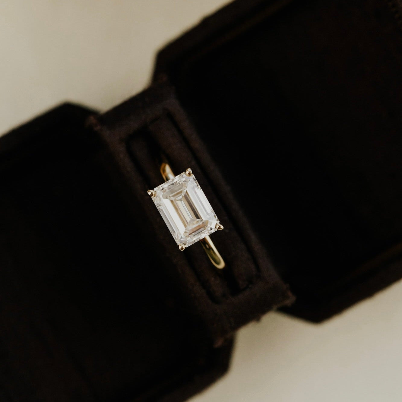 The Bennett emerald cut solitaire diamond ring in a black velvet box on a neutral background.