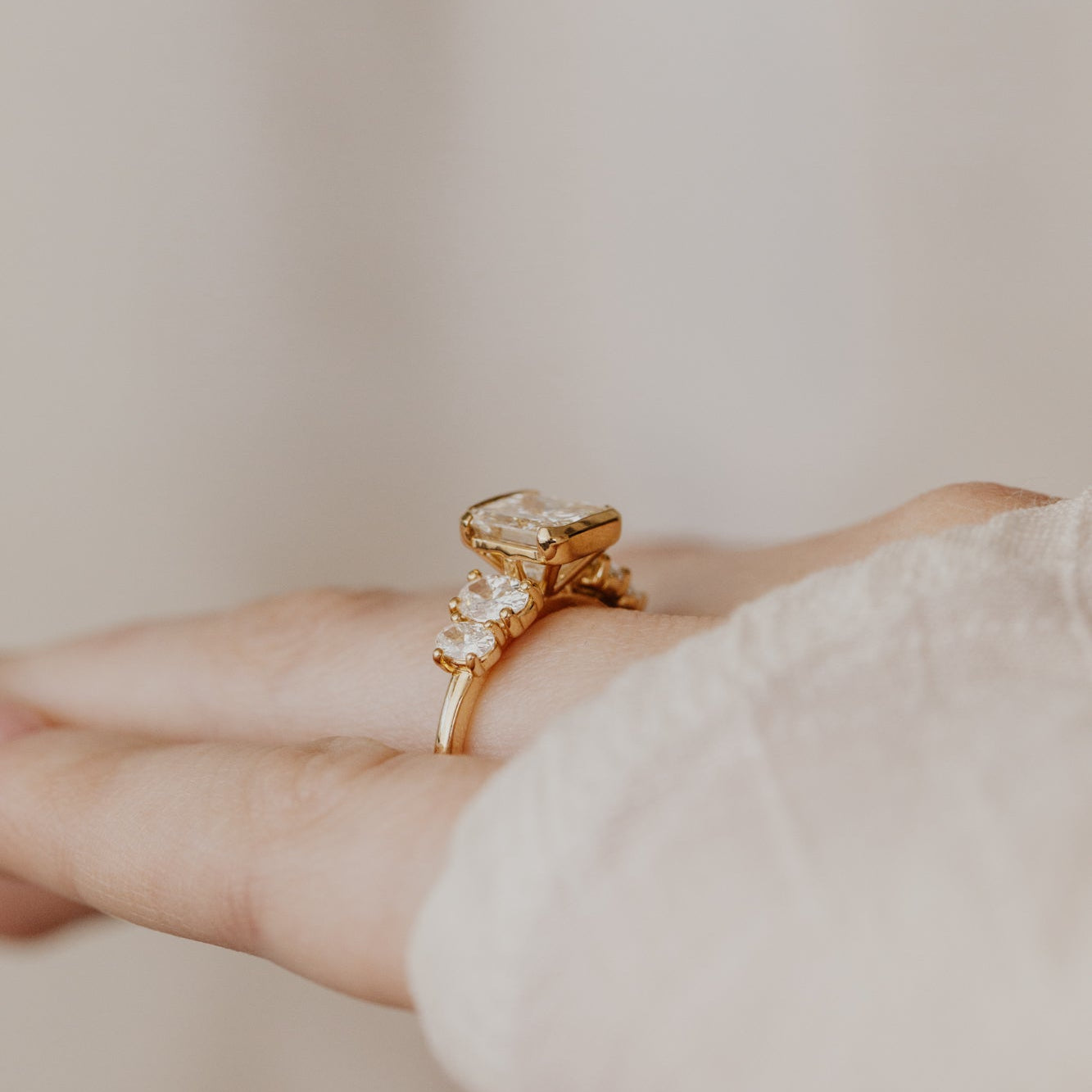 Gold ring with a large cushion diamond on a neutral background.