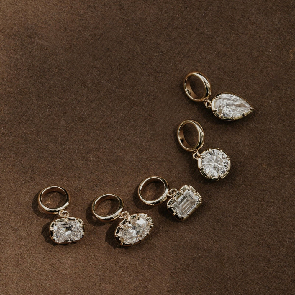 Set of lab grown diamond pendants on a brown background.