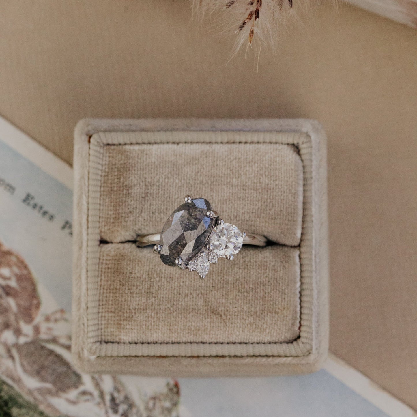 Galaxy diamond ring in a beige jewelry box on a neutral background.