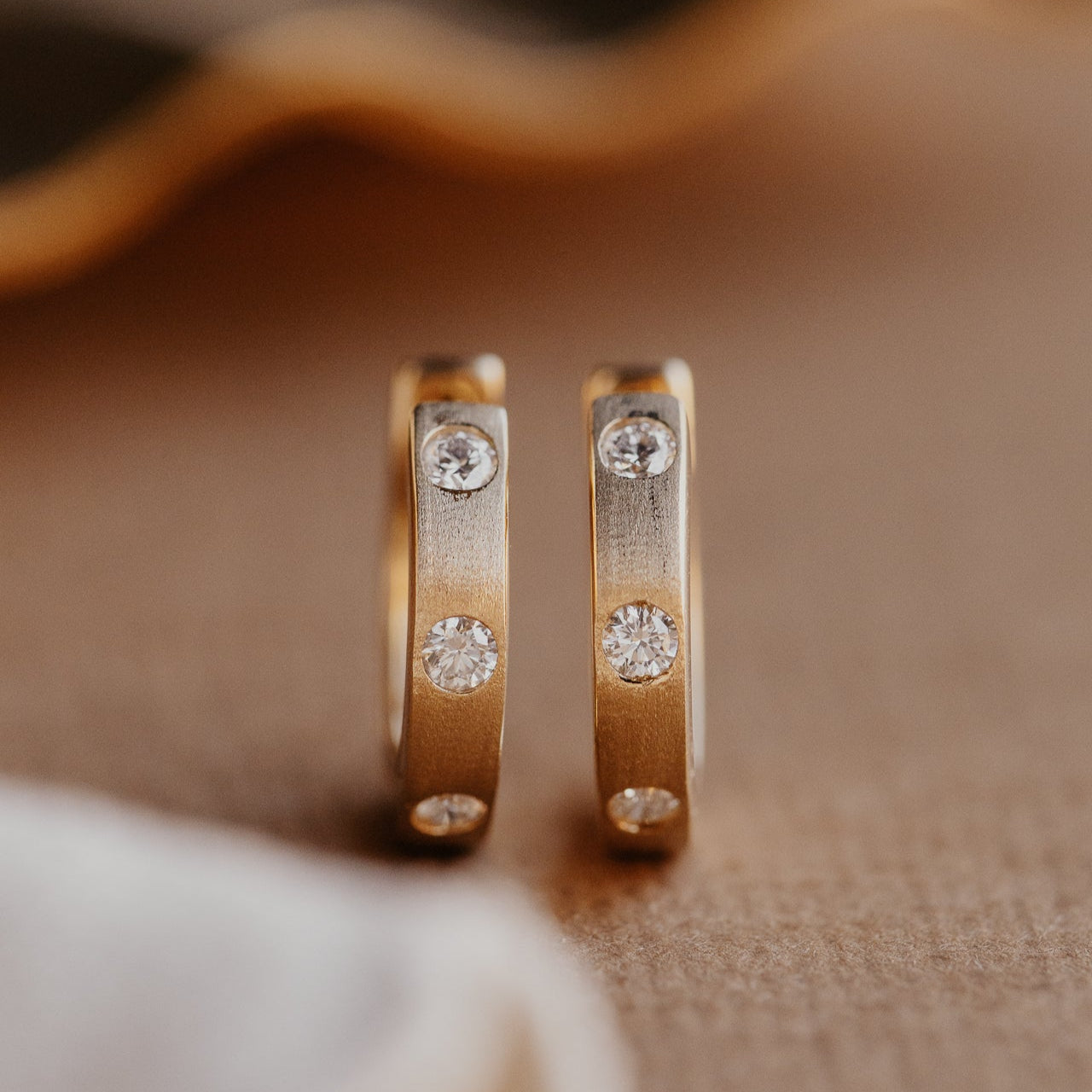 Front view of the Three Hammer Set Round Diamonds on Hoop Earrings
