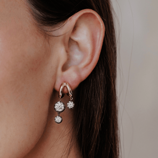14k gold double hoop, round cut, lab grown diamond dangle earrings with Black Rhodium featured on the ear of a model. 