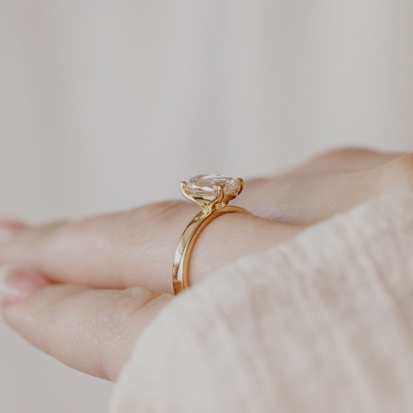 Gold Octavia ring with a champagne diamond on a blurred background.
