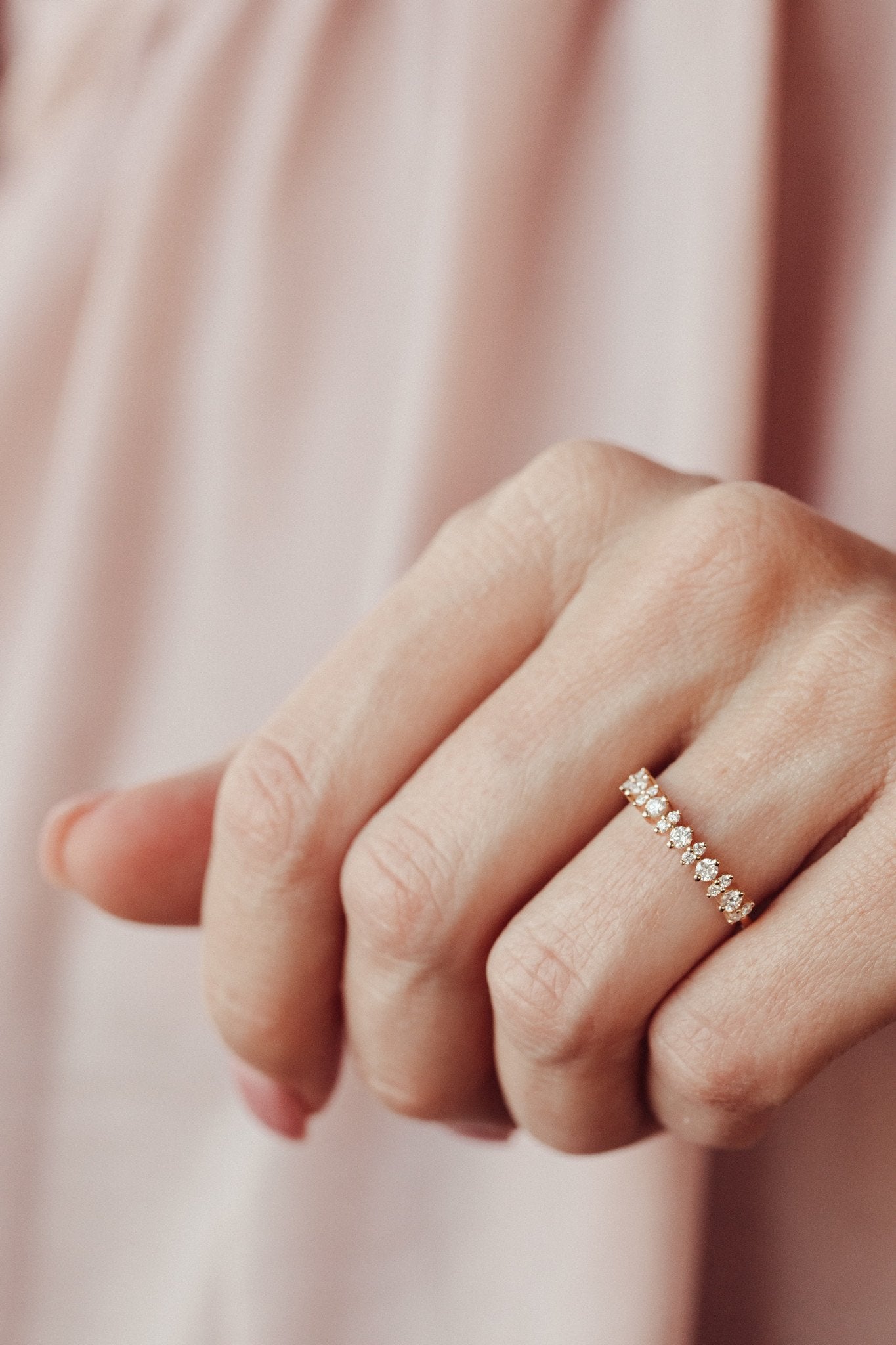 Close up of a round diamond wedding band on a woman's hand. 