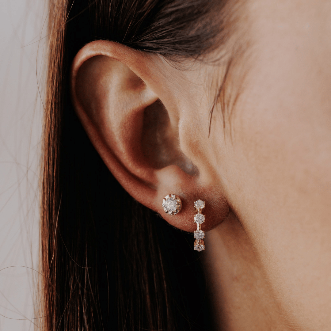 14k gold diamond 4-prong huggie earrings set showcased on the ear of a model. 