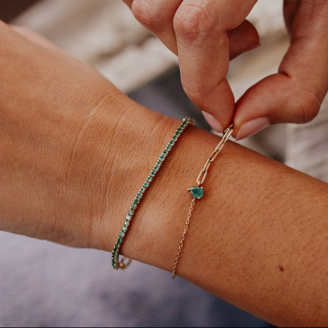 Person wearing two bracelets on a wrist with a blurred background