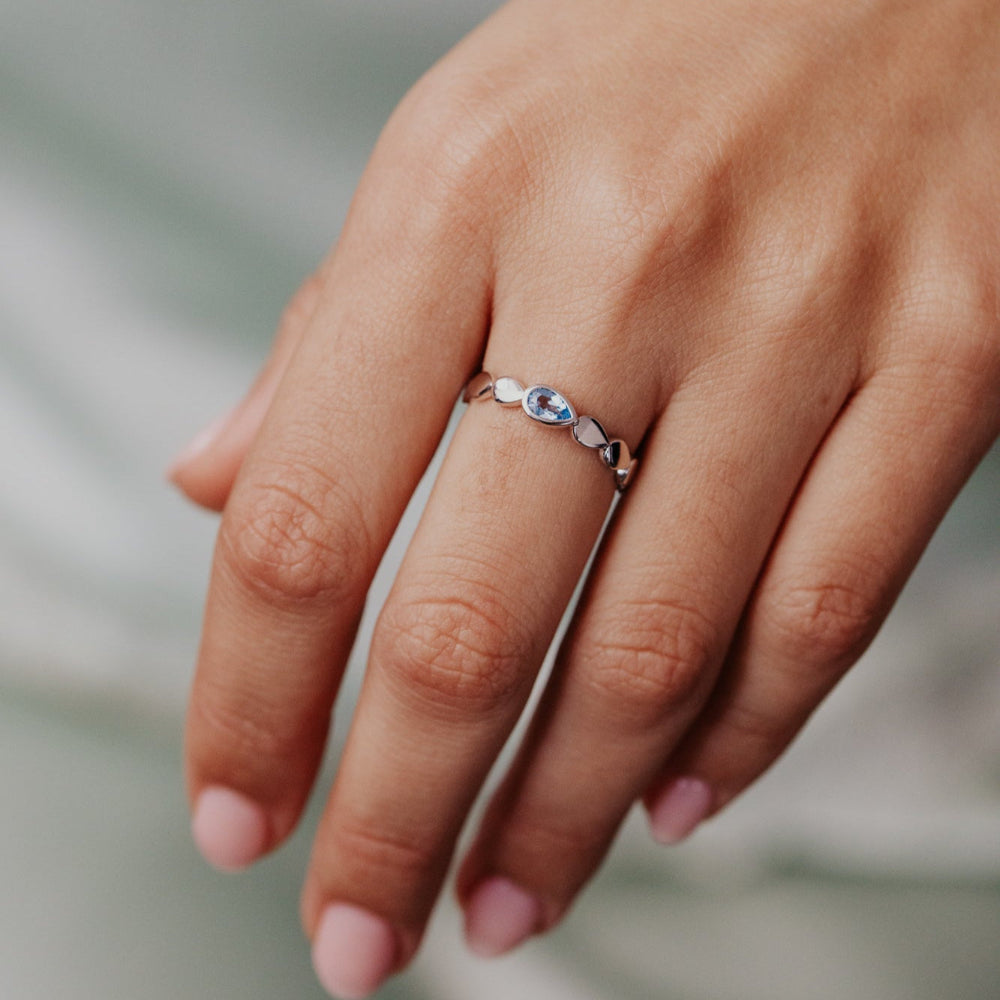 Close-up of a hand wearing a ring with a blurred background