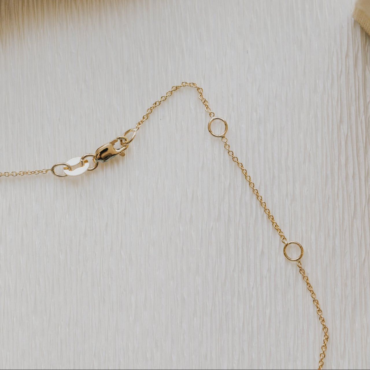 Gold chain necklace on a light wooden surface