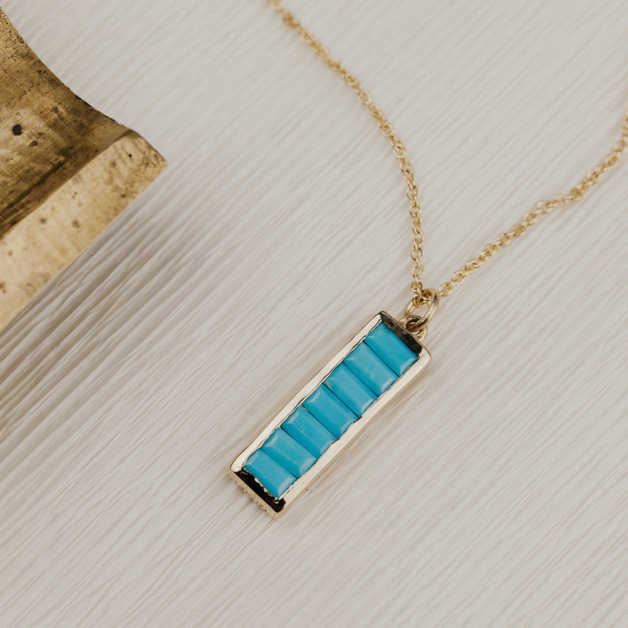 Necklace with a blue Turquoise pendant on a textured surface