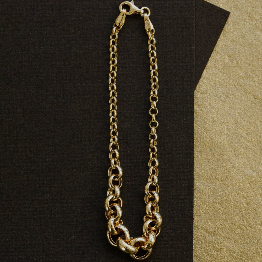 Gold chain bracelet on a dark surface