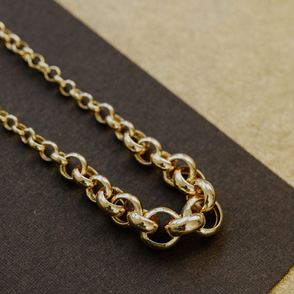 Gold chain bracelet on a brown surface