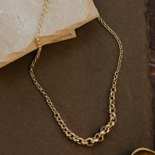 Gold chain necklace on a brown surface