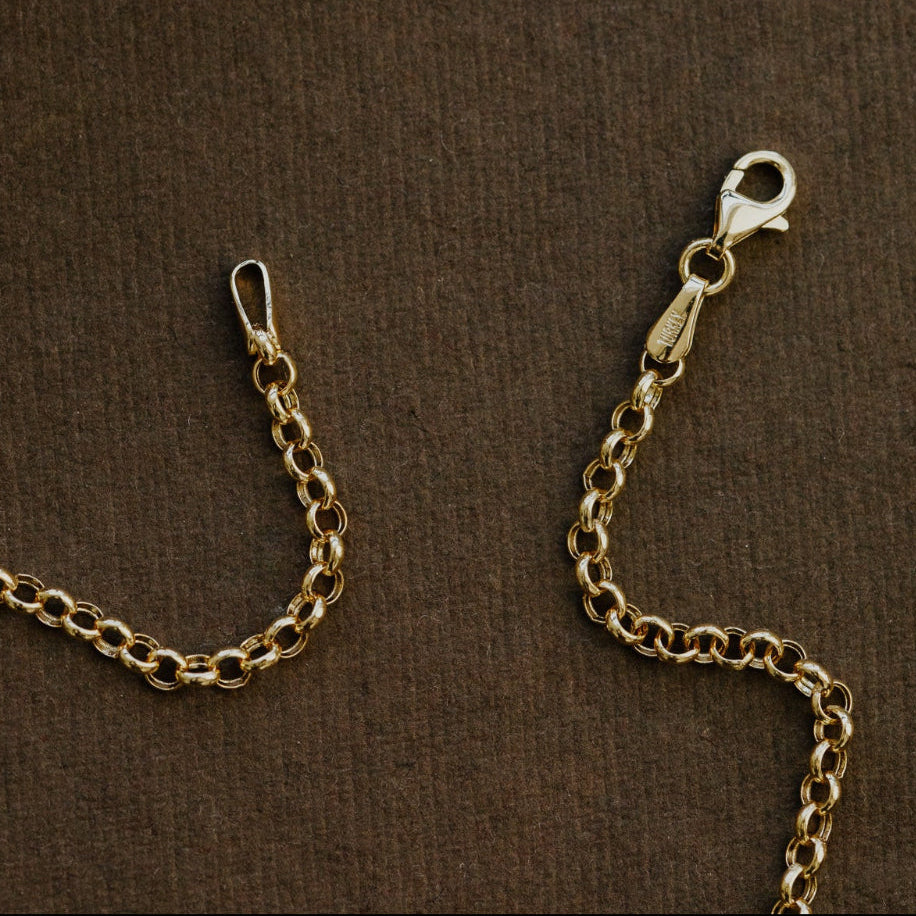 Gold chain with clasp on a brown textured surface