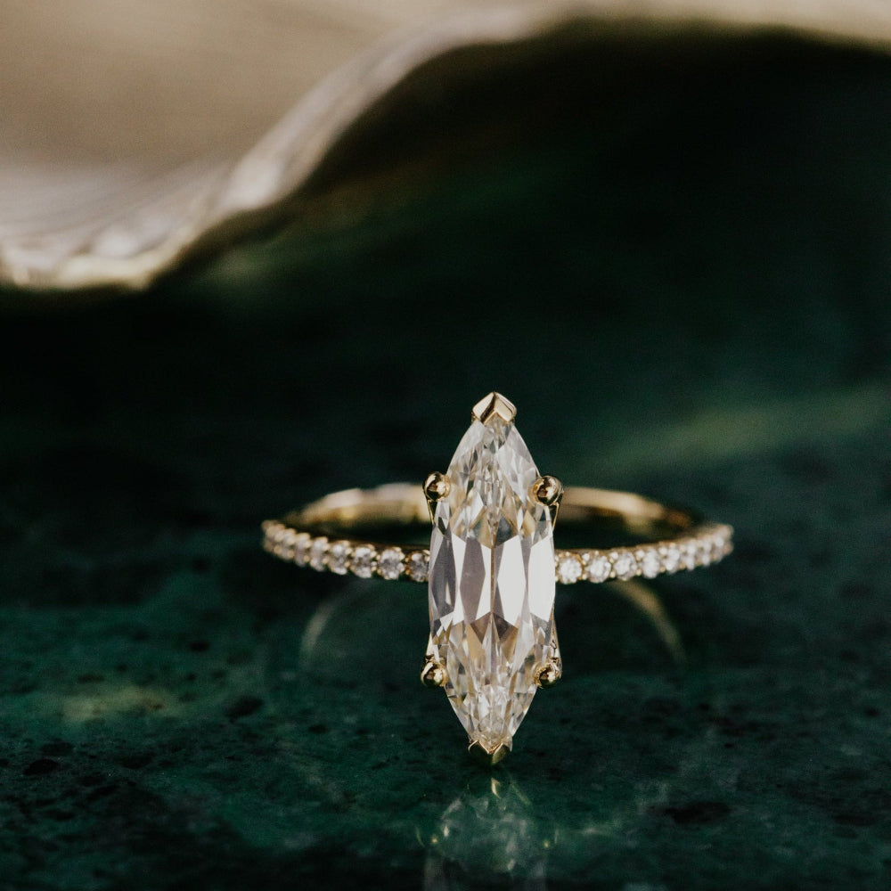 Moval lab grown diamond ring with a green textured background.