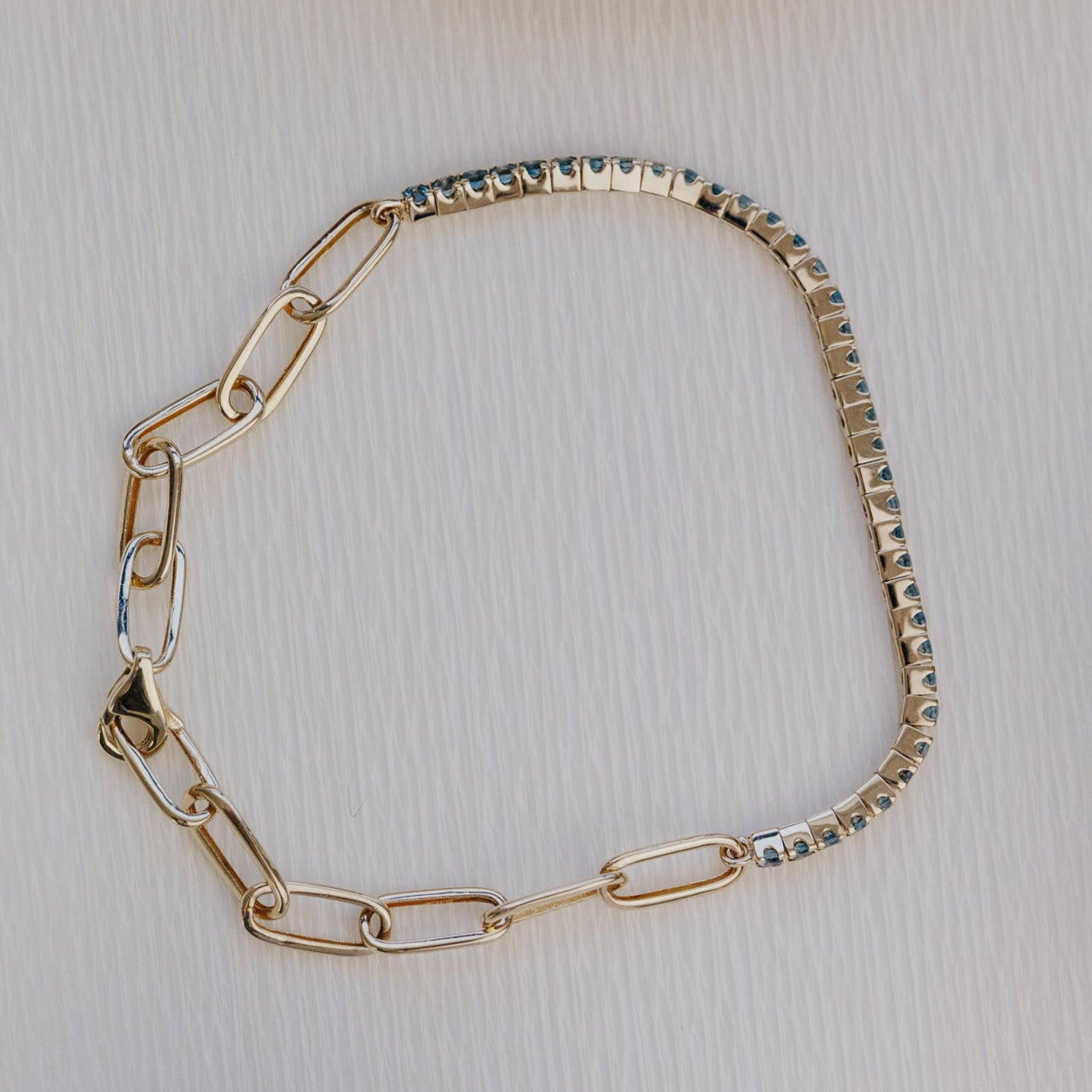 Gold chain bracelet on a textured surface
