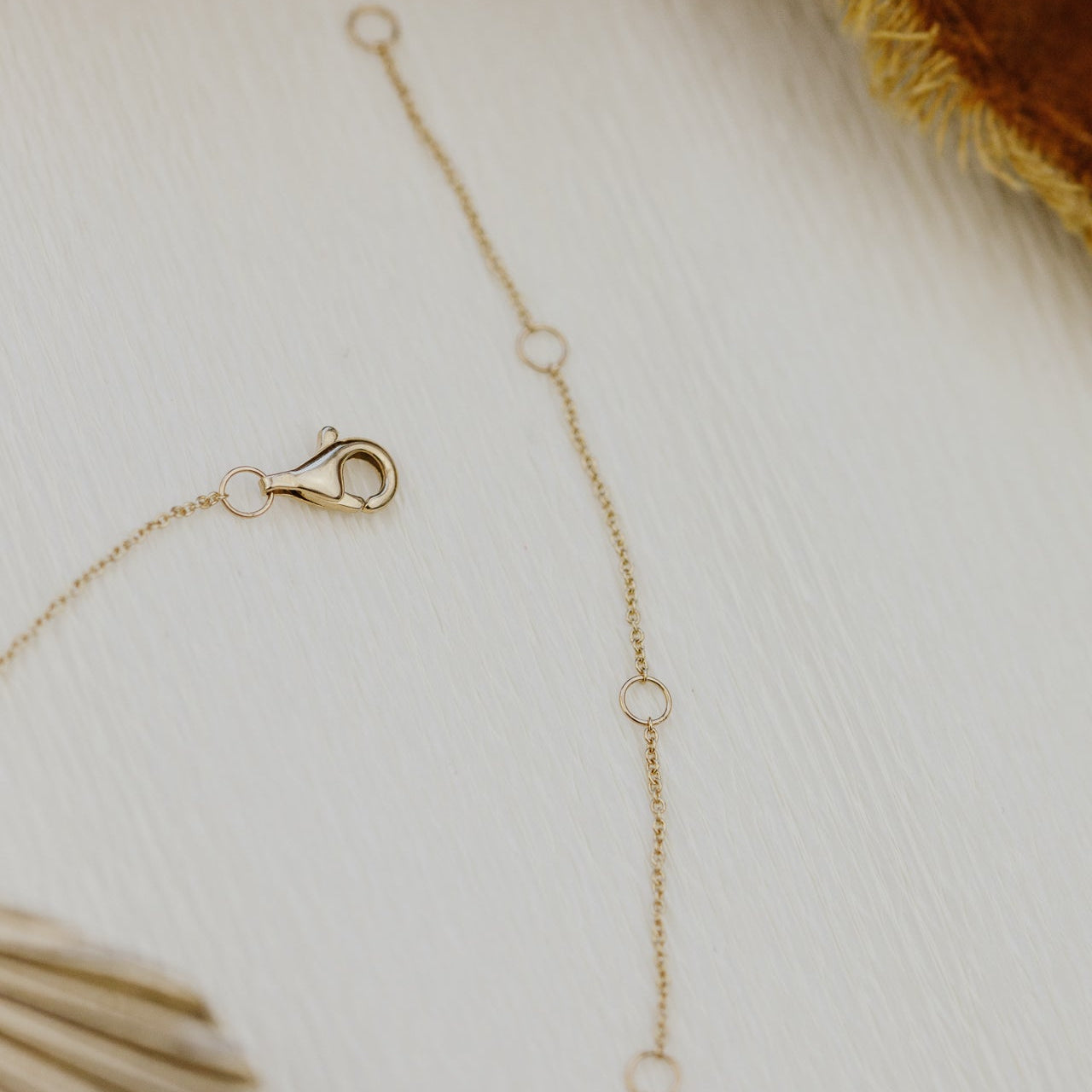 Gold necklace with clasp on a light background