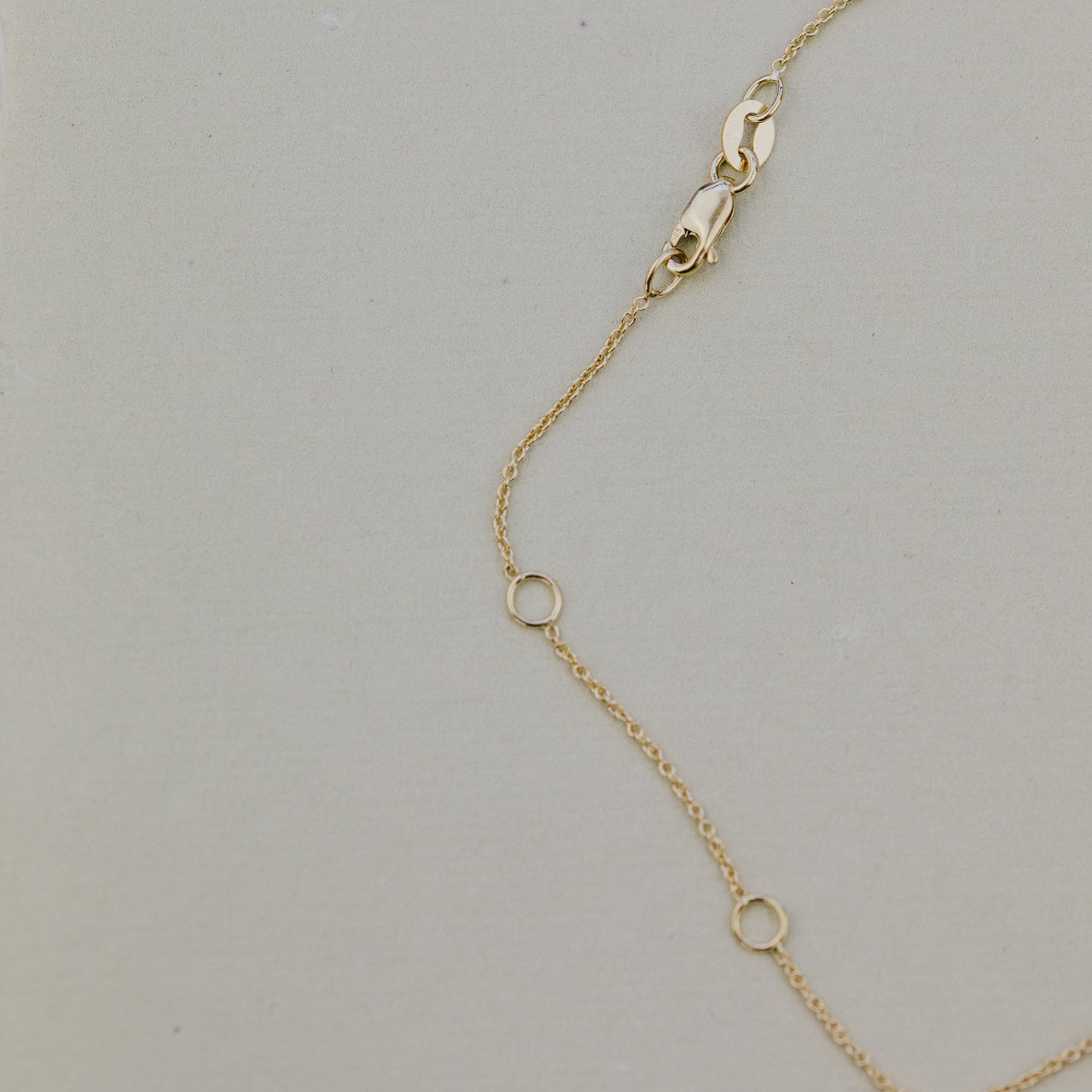 Gold chain necklace on a light gray background
