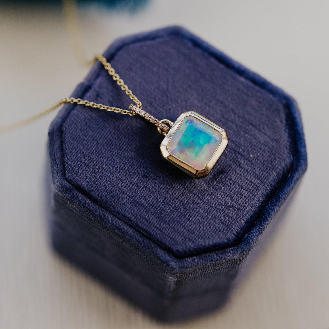 Necklace with a square Opal pendant on a blue jewelry box
