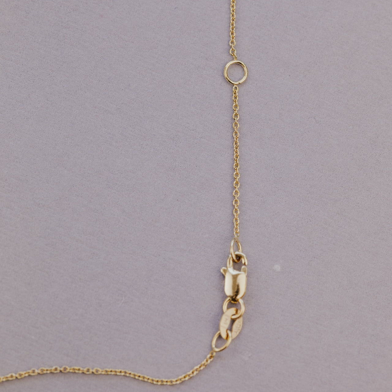 Gold necklace chain on a gray background